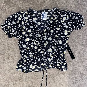 Women’s blouse with daisies and black.